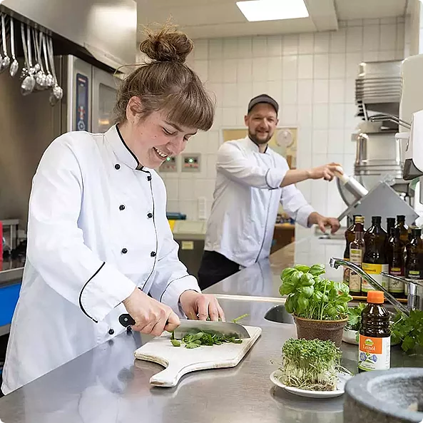 Rapunzel bietet ein breites Sortiment an Zutaten und Rohstoffen für Gastronomie, Bäckereien und Konditoren sowie für Hersteller und Verarbeiter. Eine Köchin und ein Koch bereiten mit Rapunzel Produkten Essen zu.