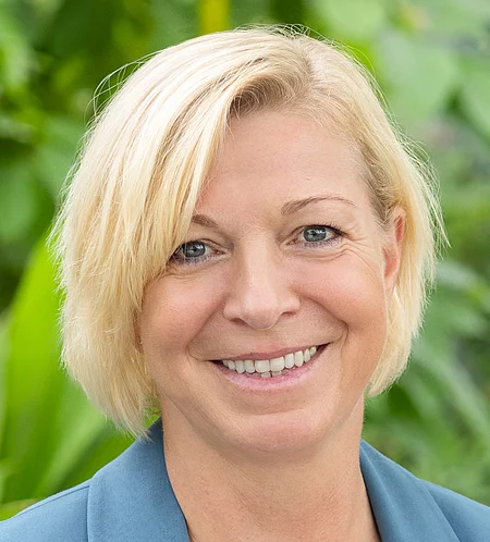 Susanna Stiegeler Rapunzel Mitarbeiterin steht vor blühender Pflanze.